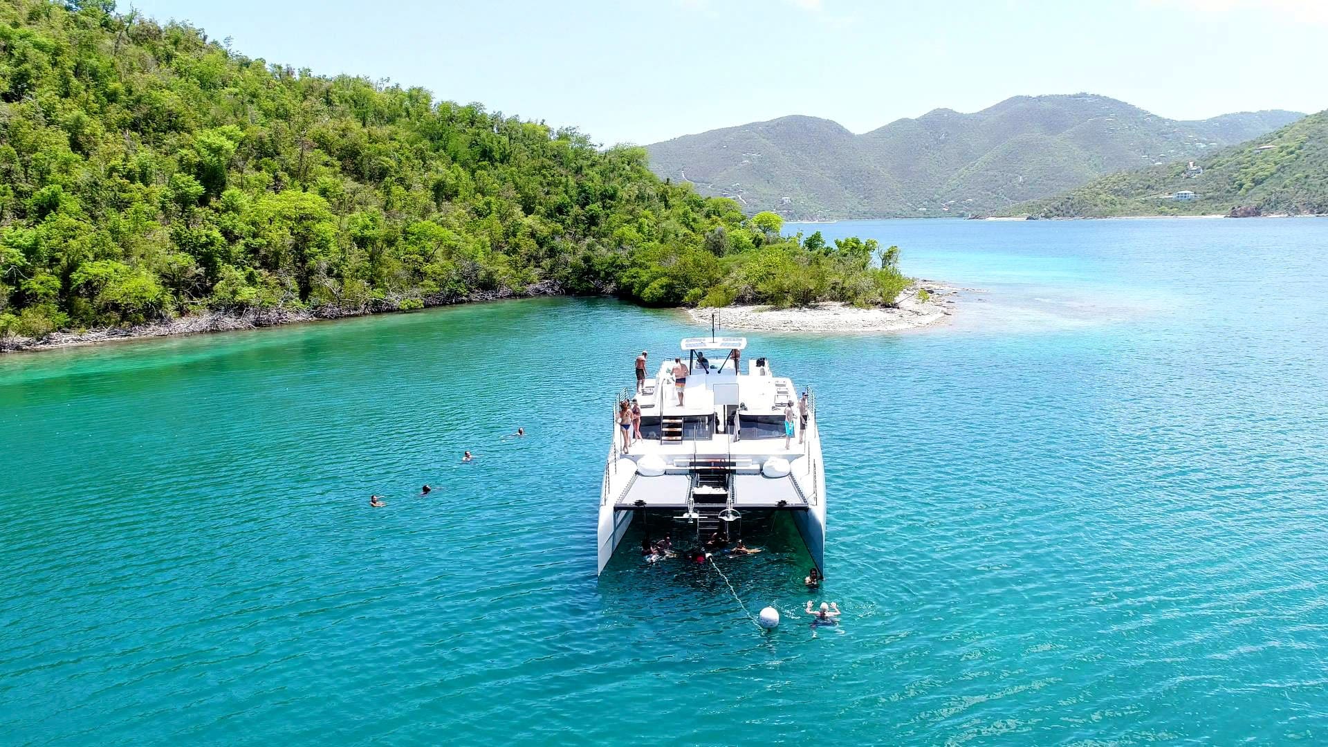 A large group on a shared charter exploring the St. John coastline, near White Point Reef Bay (Tektite Bay), south shore.